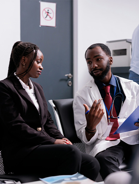  A lawyer and doctor in business suits seated together, engaged in a discussion about personal injury cases.