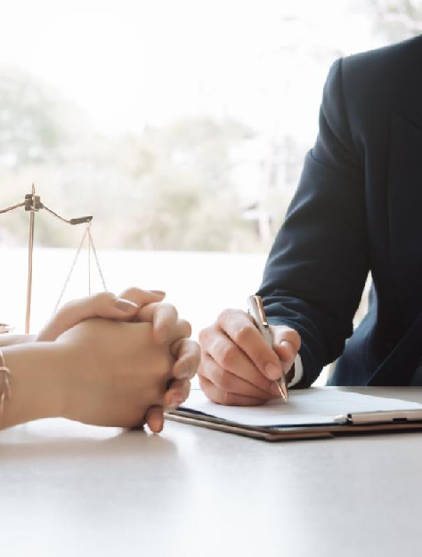 Lawyer and client are seated at a table with a scale, deliberating legal issues in a law firm environment.